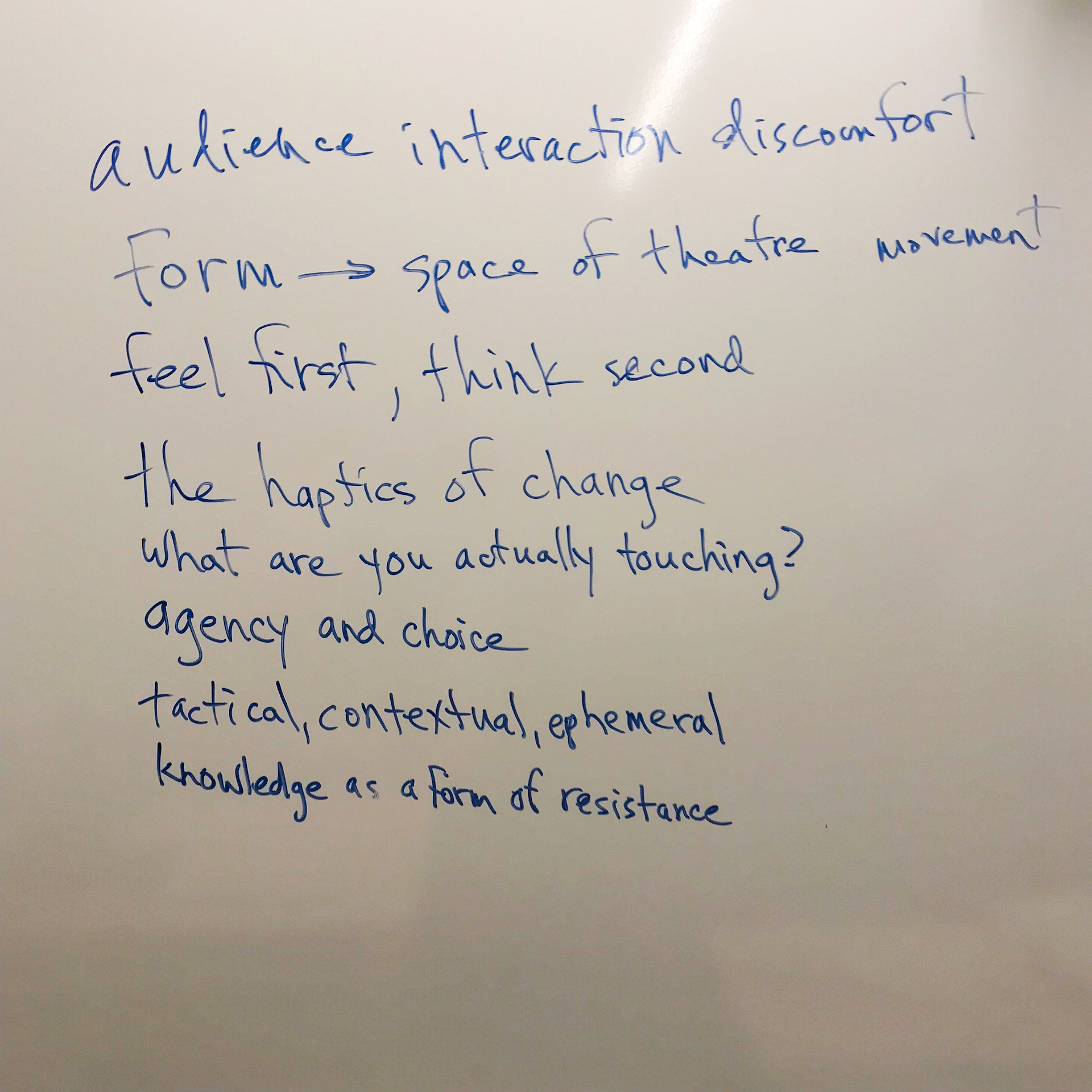 Writing on a white board that says: audience interaction discomfort, form space of theater and movement, feel first then think second, the haptics of change, what are you actually touching? Agency and choice. Tactical, contextual, ephemeral. Knowledge as a form of resistance. 